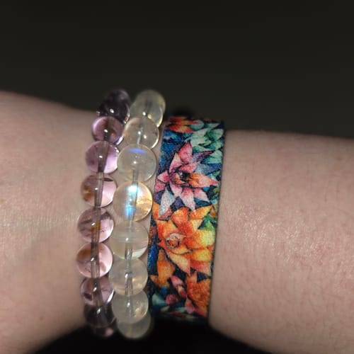 Close-up of a reviewer wearing the colorful Growth Takes Time Bracelet on their wrist, stacked with other beaded bracelets.