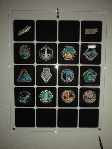 Customer's Starship Shrug Collectors Pin displayed in a clear case as part of a larger pin collection.