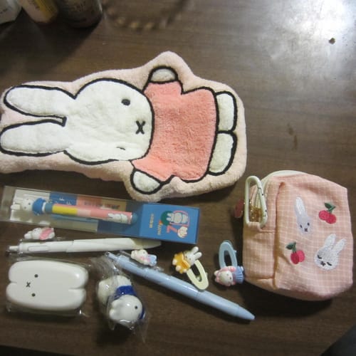 Reviewer's assortment from the Miffy Mystery Pack, showing a fuzzy pencil case, pouch, pens, and clips.
