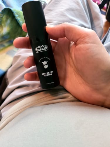 Client tenant dans sa main le flacon noir de l'Activator Serum.