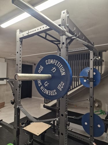 Customer's blue 20kg Strength Shop Calibrated Plate loaded onto a barbell on a grey power rack.