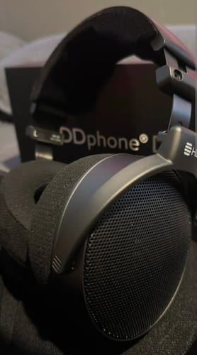 A customer's close-up of the black HEDDphone D1 headphones, showing the open-back earcup and plush velour pad.