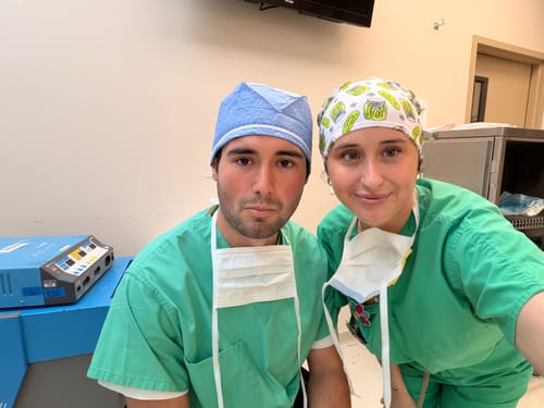 Reviewer wearing the DuoStyle Scrub Hat with a pickle pattern, posing with another person in scrubs.
