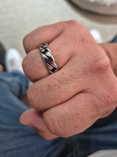 Primer plano de la mano de un cliente con el Anillo Box de acero.