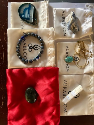 Reviewer shows the beautiful contents of their AuraBloom Subscription Box, including crystals, a bracelet, and a necklace.