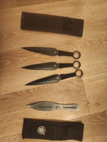 Customer's Smith & Wesson Bullseye Throwing Knife Set with its sheath, laid out next to another throwing knife and sheath.