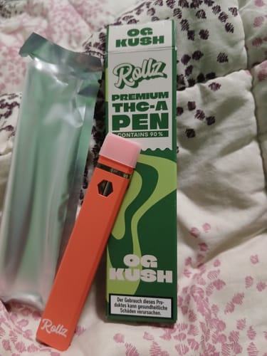 Customer's orange ROLLZ THCA Vape pen next to its green OG Kush box and packaging.