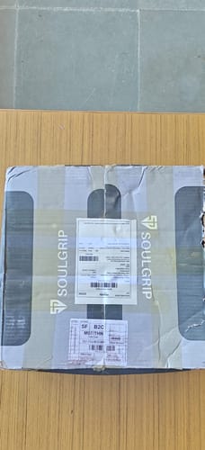 Box containing the Wings of Glory lever belt, shown on a wooden surface upon delivery.