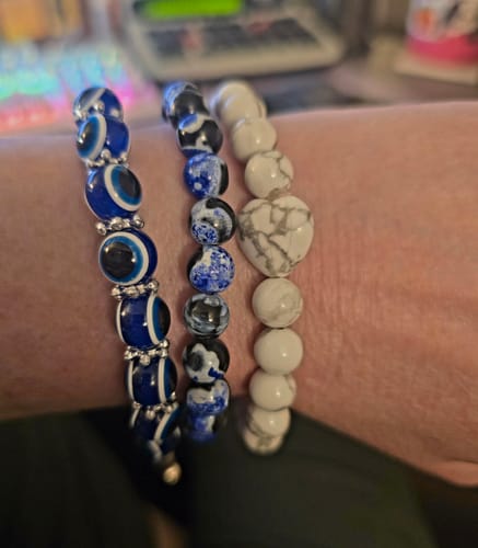 Reviewer showing their white Howlite crystal bracelet worn on the wrist alongside two other beaded bracelets.
