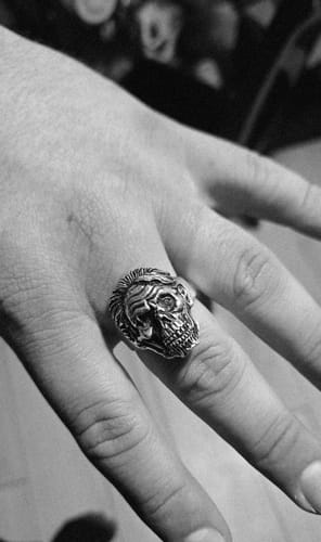 Customer wearing a detailed skull ring with a mohawk on their finger.