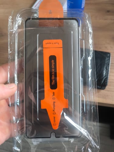 Ein Kunde zeigt die unbenutzte Glasfolie für ein Xiaomi in der Originalverpackung.