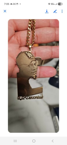 Customer holding a gold-colored custom photo engraved pendant necklace featuring a person's portrait and an engraved name.