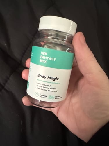 Reviewer holding a clear bottle of Her Fantasy Box Body Magic pills in their hand.