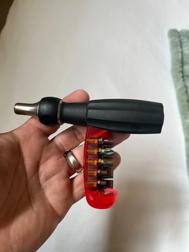 Reviewer holding the PB Swiss Tools Insider Pro Ratchet with the red bit magazine fanned out from the handle.