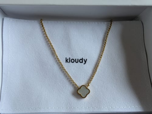 Customer's gold necklace with a single white clover-shaped pendant, from the 5-piece sale.