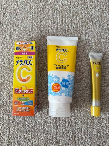 Customer's Melano CC Double Strength Vitamin C Serum shown with the matching cleanser and essence, all lined up on a carpet.