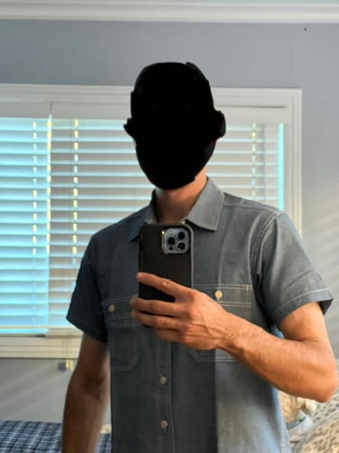 Reviewer wearing the size M Chambray Short Sleeve Work Shirt in a mirror selfie, showing the fit.