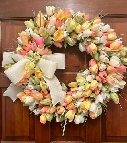 Reviewer's 14" Grapevine Wreath decorated with beautiful pastel tulips and a large off-white bow.