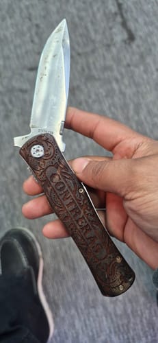 Customer holding their open Custom Text Pocket Tool, showing the 'CONTRERAS' text engraved on the detailed handle.