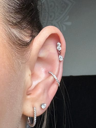 Reviewer's ear showing the silver Dangle flatback stud worn in a helix piercing.