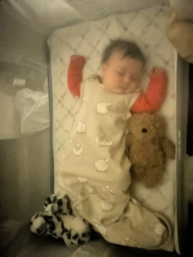 A reviewer's baby sleeps snugly in the sheep-patterned 4 Season Ultimate Baby Sleep Bag.