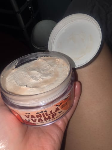 Customer holding an open jar of Vanilla Vamp Whipped Body Butter, showing the whipped product texture.
