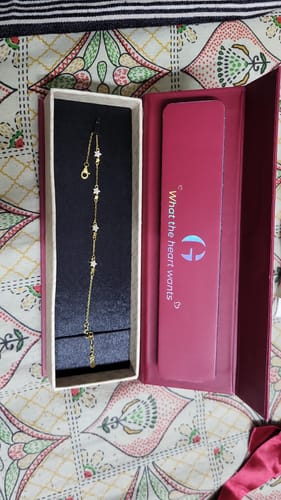 Customer's delicate Golden Paired Star Bracelet displayed in its open pink gift box.
