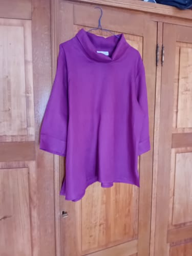 Avis d'une cliente : la blouse Catherine en lin bougainvillier suspendue sur un cintre.
