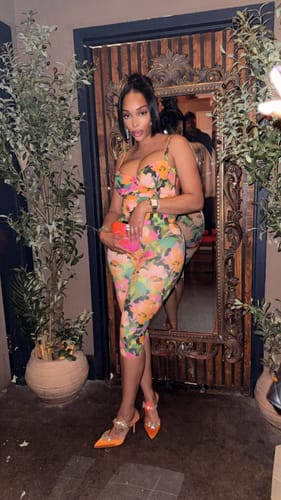 Reviewer posing in the vibrant Naked Print Open Back Bodysuit and matching leggings indoors.
