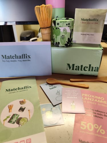 Un cliente muestra su pack de iniciación de Té Matcha Premium, con un batidor de bambú y varios envases de la marca sobre una mesa.