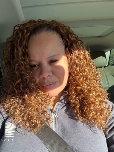 Customer in a car wearing voluminous, curly #30 Light Brown Water Wave Human Crochet Hair.