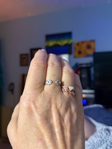 A reviewer's hand wearing the silver-colored Paw Hug Ring on an index finger.
