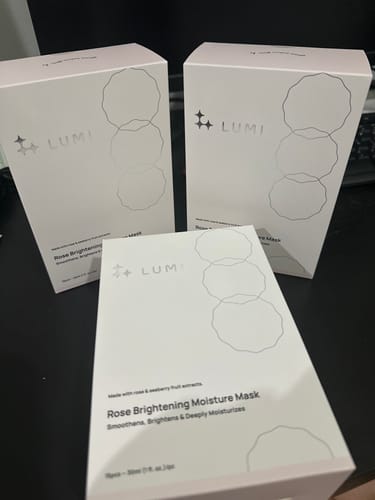 Customer's three white boxes of the Rose Brightening Moisture Mask arranged on a desk.