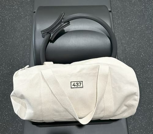 Reviewer's natural Duffle bag shown on a Pilates bench with a workout ring.
