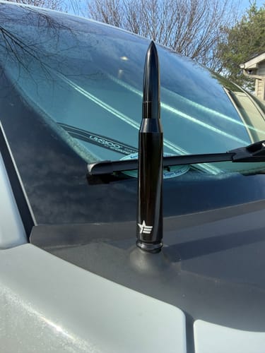 A reviewer's black 50 Cal Bullet Antenna installed on the hood of their vehicle.