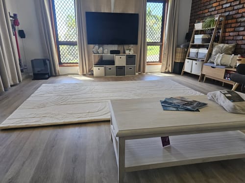 Customer's large, cream Mellow Mat with a carved pattern laid out in a contemporary living room.