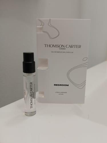 Customer's 2ml sample vial of Shelby Lane eau de parfum next to its white packaging on a table.
