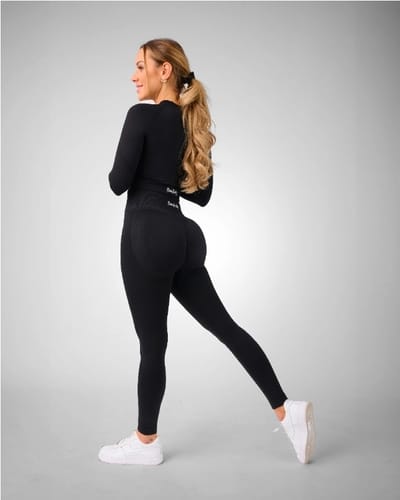 Kundin in dem schwarzen Contour Seamless Set von der Seite, das eine schmeichelhafte Figur macht.