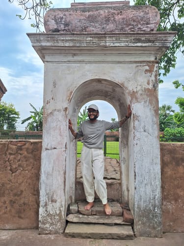 Customer standing in an archway, showing the comfortable fit of the white RootsUp Yoga Pants.