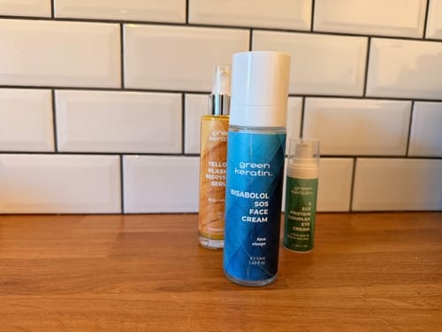 La Crème Régénérante Pour Le Visage BISABOLOL d'un client sur un comptoir en bois, à côté d'autres produits de soin.