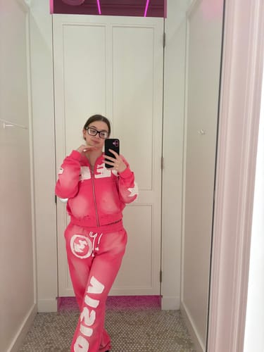 Reviewer taking a mirror selfie in a fitting room, wearing the full pink SEEK VISIONZ SET.