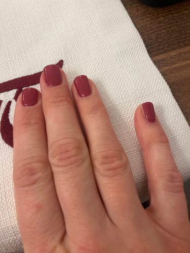Hand einer Kundin, die ihre manikürten Nägel mit den UV Gel Nagelfolien 'Grapevine Twist' zeigt.