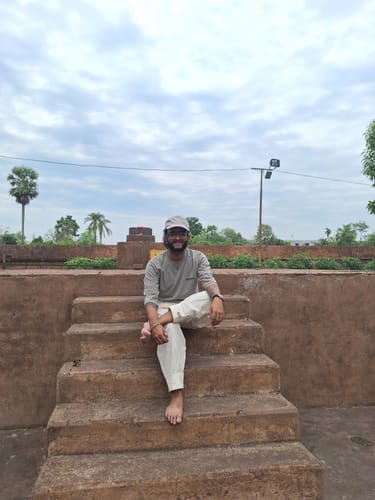 Customer sitting barefoot on stone steps in comfortable, white RootsUp Yoga Pants.