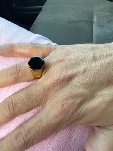 Primer plano del Anillo Classic Onyx Oro en la mano de un cliente.