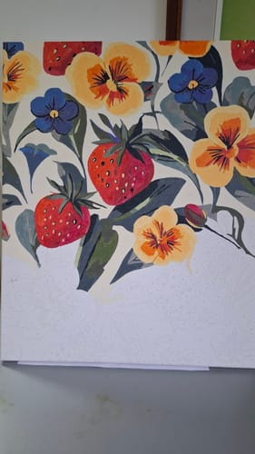 לקוח/ה מציג/ה את ערכת הצביעה לפי מספרים כשהיא צבועה חלקית, עם פרחים ותותים צבעוניים.