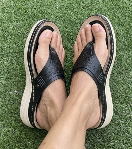 Customer wearing black Grace sandals with a thick, supportive sole and embossed floral straps.