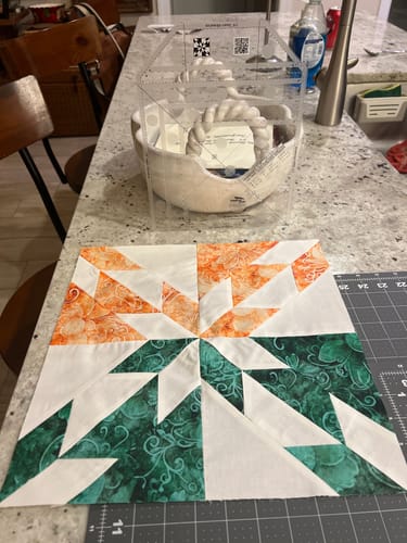 Reviewer's Creative Grids Hunter's Star Trim Tool shown with a green and orange quilt block made using it.