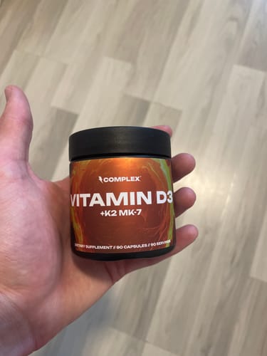 Customer holding the small tub of Vitamin D3+K2 MK-7 in their hand.