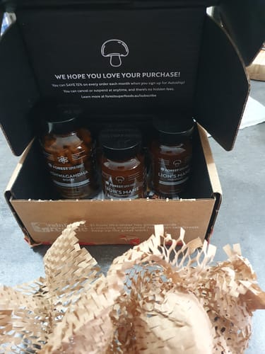 Customer's open shipping box containing their order of supplements, including the Organic Moringa Capsules.