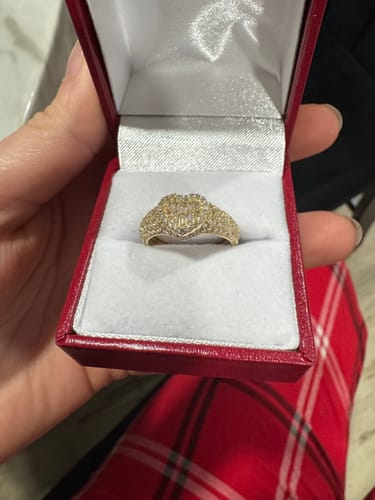 Customer holding open a red ring box to display a sparkling 14K Cz Heart Baguette Ring.